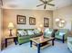 Living room with a plush green sofa, striped chairs, and tasteful decor including palm tree-themed artwork at 6059 Bahia Del Mar Blvd # 235, St Petersburg, FL 33715