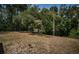 Spacious backyard with a tall antenna, lush trees, and open space at 6423 Bass Rd, Weeki Wachee, FL 34607