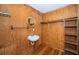 Small bathroom featuring wood paneling, a round mirror, and basic fixtures at 6423 Bass Rd, Weeki Wachee, FL 34607