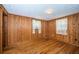 Bedroom featuring wood walls, hardwood floors, and natural lighting at 6423 Bass Rd, Weeki Wachee, FL 34607