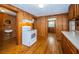 Kitchen featuring wood walls, hardwood floors, and white appliances at 6423 Bass Rd, Weeki Wachee, FL 34607