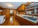 Kitchen featuring wood walls, hardwood floors, wood cabinets, and stainless sink at 6423 Bass Rd, Weeki Wachee, FL 34607