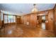 Living room featuring wood walls, hardwood floors, and access to the kitchen at 6423 Bass Rd, Weeki Wachee, FL 34607
