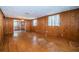Spacious living room with wood walls, original hard wood floors, and natural light at 6423 Bass Rd, Weeki Wachee, FL 34607