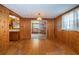 Living room featuring wood walls, hardwood floors, and an adjacent kitchen at 6423 Bass Rd, Weeki Wachee, FL 34607
