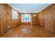 Spacious living room with wood walls, original hard wood floors, and natural light at 6423 Bass Rd, Weeki Wachee, FL 34607