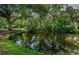Scenic pond surrounded by mature trees and green foliage reflecting in the still water at 6423 Bass Rd, Weeki Wachee, FL 34607