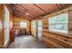 Cozy room with wood walls, multiple windows, and a concrete floor at 6423 Bass Rd, Weeki Wachee, FL 34607