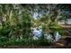 Beautiful water view with mature trees, and the reflection of blue sky and clouds in a serene residential neighborhood at 6423 Bass Rd, Weeki Wachee, FL 34607