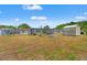 Large backyard featuring storage shed and screened pool provides ample space for outdoor activities and storage at 6424 Ponder Dr, Port Richey, FL 34668