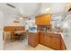 The kitchen features wooden cabinets, a ceiling fan and views of the living room at 6424 Ponder Dr, Port Richey, FL 34668