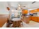 The kitchen features wooden cabinets, a ceiling fan and views of the living room at 6424 Ponder Dr, Port Richey, FL 34668