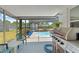Outdoor kitchen and screened-in pool area create a perfect space for outdoor living and entertaining guests at 6424 Ponder Dr, Port Richey, FL 34668