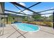 Dive into the screened-in pool, surrounded by lush greenery, perfect for year-round enjoyment at 6424 Ponder Dr, Port Richey, FL 34668