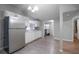 Functional kitchen features white cabinets, stainless steel refrigerator, and a charming arched doorway at 7211 & 0 Sunnyside Dr, Brooksville, FL 34601