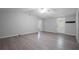 Bright living room featuring light walls, vinyl plank flooring, ceiling fan, and white door at 7211 & 0 Sunnyside Dr, Brooksville, FL 34601