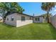 View of the backyard with a lush green lawn and a charming single-story home at 7494 7Th N St, St Petersburg, FL 33702