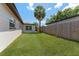 Green backyard featuring a privacy fence and a mature palm tree providing shade at 7494 7Th N St, St Petersburg, FL 33702