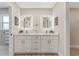 Bathroom with double vanity, quartz countertop, illuminated mirrors, brushed gold hardware, and decorative accents at 7494 7Th N St, St Petersburg, FL 33702