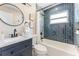 This bathroom features a modern vanity, round mirror and a shower with stylish blue tile at 7494 7Th N St, St Petersburg, FL 33702