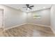 This is a bright bedroom with wood-look floors, a ceiling fan, and two windows at 7494 7Th N St, St Petersburg, FL 33702