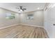 This is a well-lit bedroom featuring wood-look floors, a ceiling fan, and a closet at 7494 7Th N St, St Petersburg, FL 33702