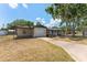 Charming single-story home with a covered front porch, a garage, and a long driveway at 7494 7Th N St, St Petersburg, FL 33702
