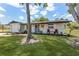 Charming single-story home with a well-maintained lawn, landscaping, and cozy front porch with red Adirondack chairs at 7494 7Th N St, St Petersburg, FL 33702