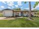 Charming single-story home featuring a well-manicured lawn, fresh landscaping, and inviting front porch at 7494 7Th N St, St Petersburg, FL 33702