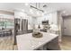 Modern island kitchen with stainless steel appliances, white cabinetry, and quartz countertops at 7494 7Th N St, St Petersburg, FL 33702