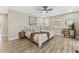 Bedroom with hardwood floors, ceiling fan, decorative painting, natural light, and neutral tones at 7494 7Th N St, St Petersburg, FL 33702