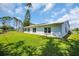 Green backyard with a well-maintained lawn and white exterior walls at 9136 42Nd N Ln, Pinellas Park, FL 33782