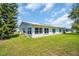 A view of the backyard featuring a lush lawn and white exterior walls at 9136 42Nd N Ln, Pinellas Park, FL 33782