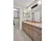 Bathroom featuring a double sink vanity and doorway leading to storage area at 9136 42Nd N Ln, Pinellas Park, FL 33782