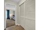View of bedroom with neutral walls and blue curtains, seen through a doorway with a louvered closet on the right at 9136 42Nd N Ln, Pinellas Park, FL 33782