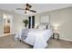 A calming bedroom features neutral walls, carpet, and a ceiling fan with a view to the en-suite bathroom and bright window at 9136 42Nd N Ln, Pinellas Park, FL 33782