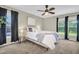 Bright bedroom with a ceiling fan, a neutral color scheme and carpeted floor with a beautiful green view from the window at 9136 42Nd N Ln, Pinellas Park, FL 33782