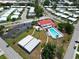 Aerial view of the community recreation area with a pool, clubhouse, covered picnic area, and parking at 9136 42Nd N Ln, Pinellas Park, FL 33782
