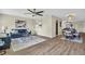 Open-concept living room featuring a blue sofa, modern decor, and wood flooring at 9136 42Nd N Ln, Pinellas Park, FL 33782