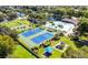 Aerial shot highlighting community tennis courts, playground, and swimming pool amidst lush landscaping at 923 Tuscanny St, Brandon, FL 33511