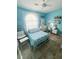 Vibrant bedroom with blue walls, white furniture, a chair with pillows, and a window overlooking the yard at 923 Tuscanny St, Brandon, FL 33511