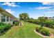 Well-maintained backyard featuring green lawn, mature landscaping, a palm tree, and patio furniture at 9335 Stonewall, New Port Richey, FL 34655