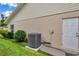 Exterior side view of home shows the AC unit, the stucco and siding, and a backdoor entrance at 9335 Stonewall, New Port Richey, FL 34655