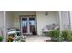 Inviting front porch with brick flooring, comfortable seating, and lush landscaping creating a warm and welcoming entry at 9335 Stonewall, New Port Richey, FL 34655