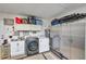 Efficient laundry room featuring modern washer and dryer, wash sink, and ample storage space at 9335 Stonewall, New Port Richey, FL 34655