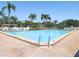 A sparkling community pool beckons with clear water, surrounded by lounge chairs and swaying palm trees at 9335 Stonewall, New Port Richey, FL 34655