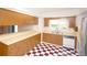 Classic kitchen features wood cabinets, checkered floors, and stainless steel refrigerator at 934 Jerry Smith Rd, Dover, FL 33527
