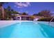 Inviting pool with clear blue water, surrounded by lush landscaping and a covered patio area at 934 Jerry Smith Rd, Dover, FL 33527