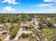 An aerial view shows a home in a quiet neighborhood with mature trees and landscaping at 936 Alcazar Way S, St Petersburg, FL 33705