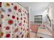 Quaint bathroom showcasing retro pink tiles, a unique floral shower curtain, and a charming sink at 936 Alcazar Way S, St Petersburg, FL 33705